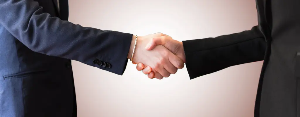 Two businessmen shaking signifying a successful BPO partnership
