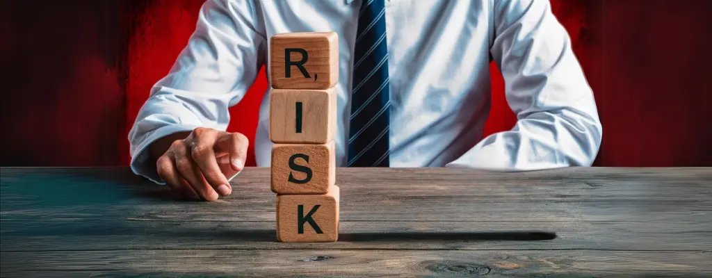 A man stacking letter blocks that read “risk”, showing how BPO can manage potential risks