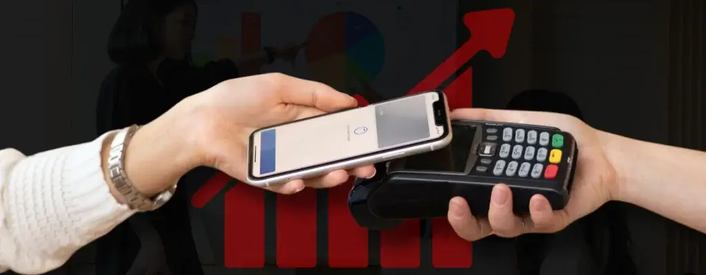 A woman holding a phone while another person holds a POS terminal, getting ready for a transaction